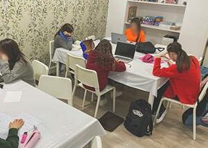 Grupo de estudiantes trabajando en tareas con ordenadores portátiles